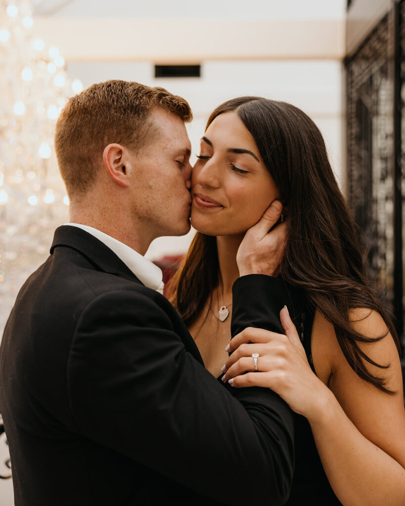 man kisses woman on her cheek