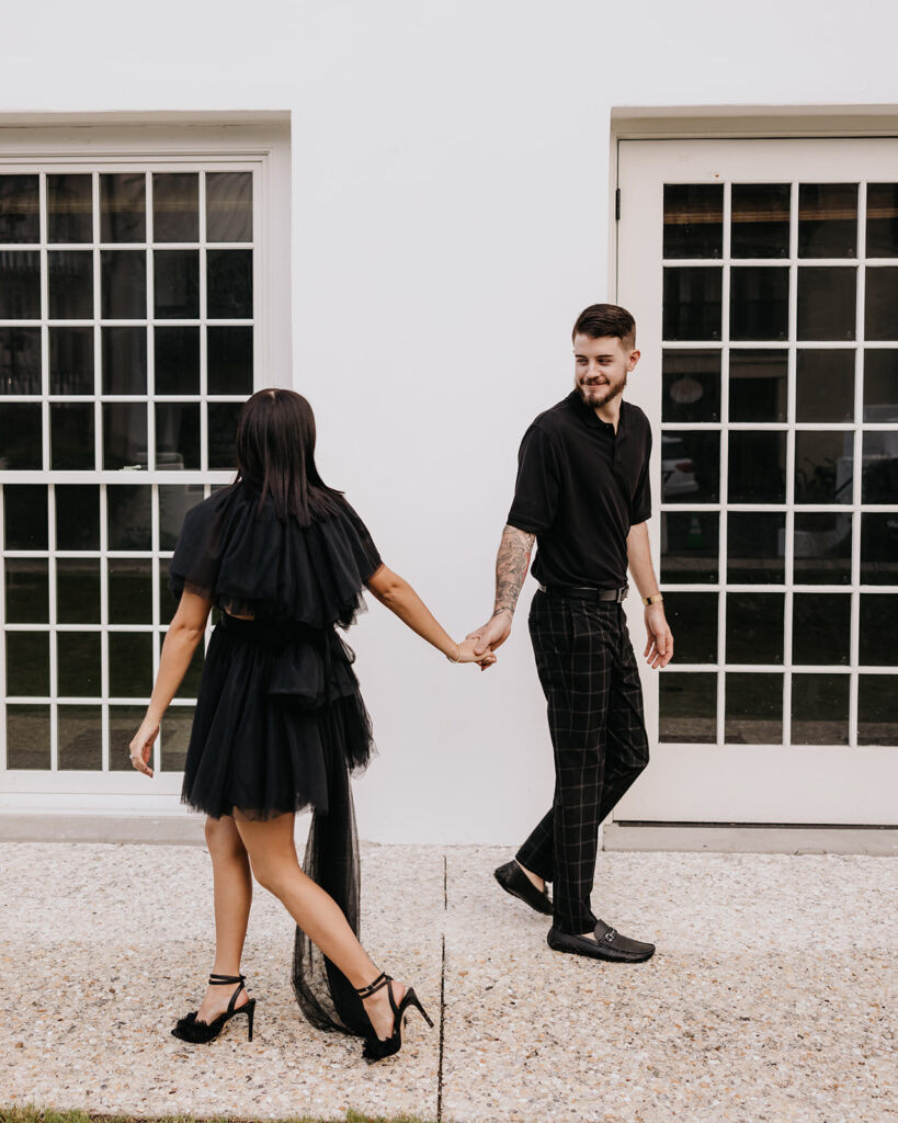 Man and woman walk past each other and hold hands