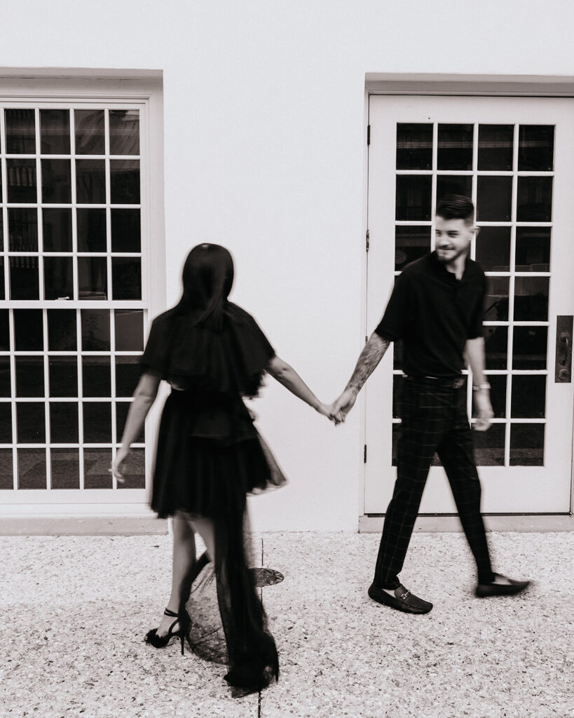 Man and woman walk past each other and hold hands