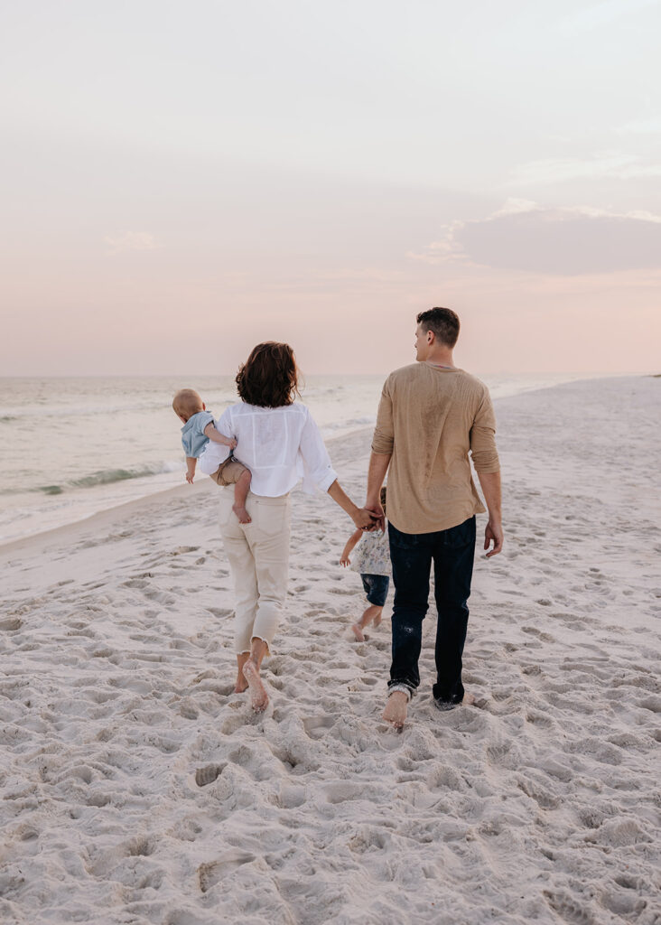 young family walks along the beach