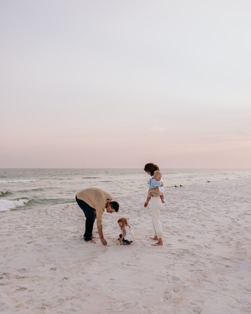 young family looks for seashells