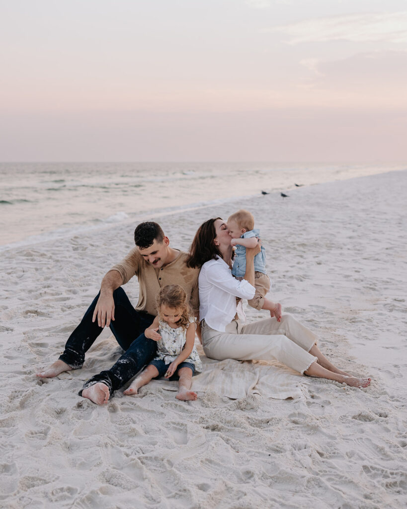 young family plays on the beach