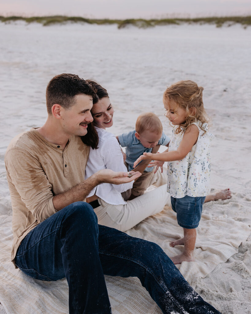 young family plays on the beach