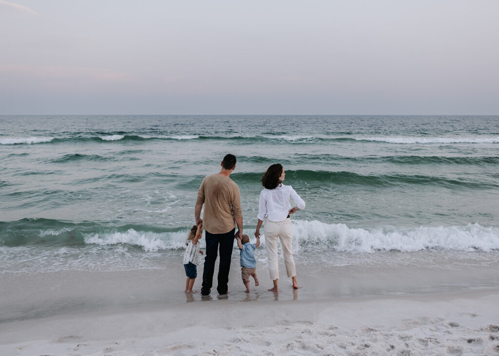 young family watches the waves