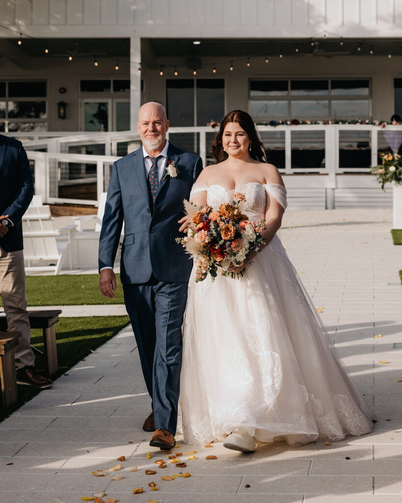 a bride and her father walk down the aisle