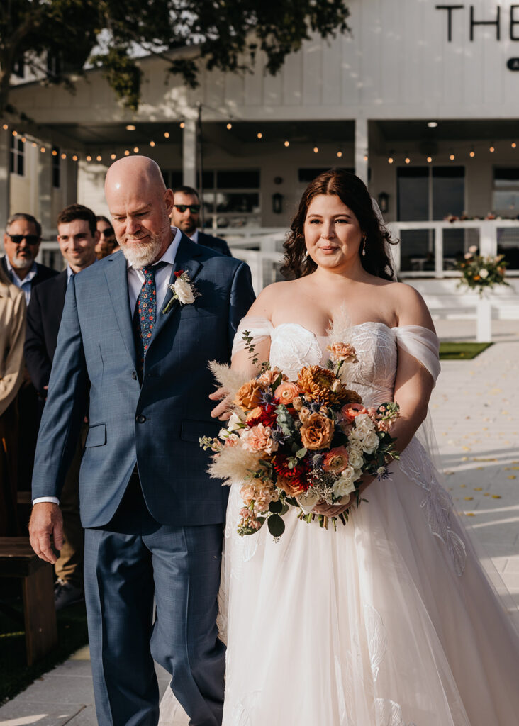 a bride and her father walk down the aisle