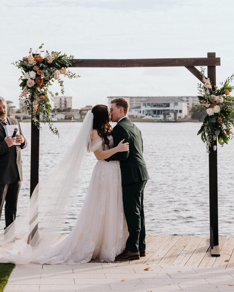 bride and groom share their first kiss
