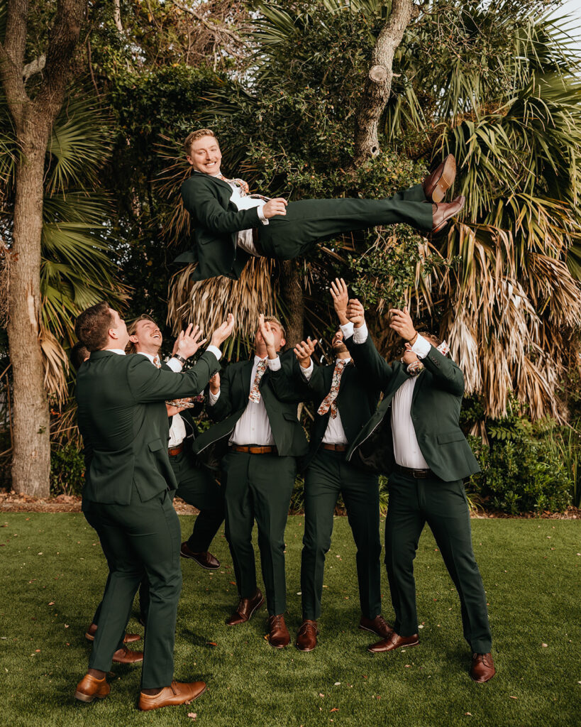 groomsmen toss groom into the air
