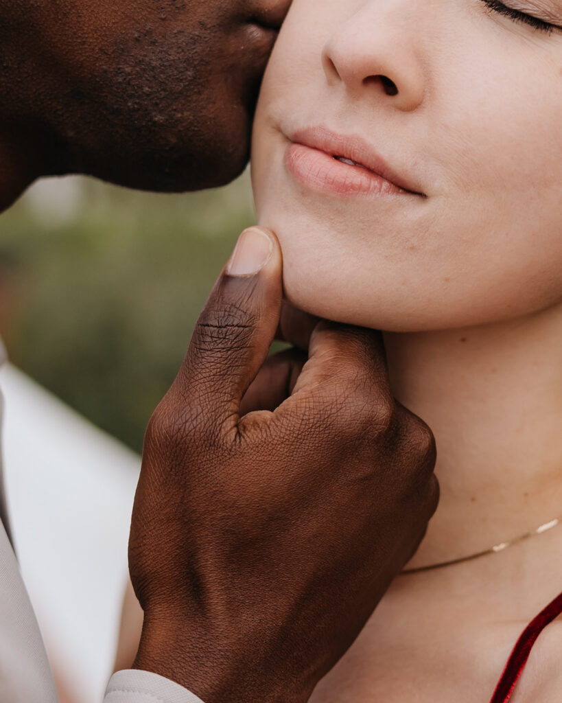 man lightly kisses woman's face
