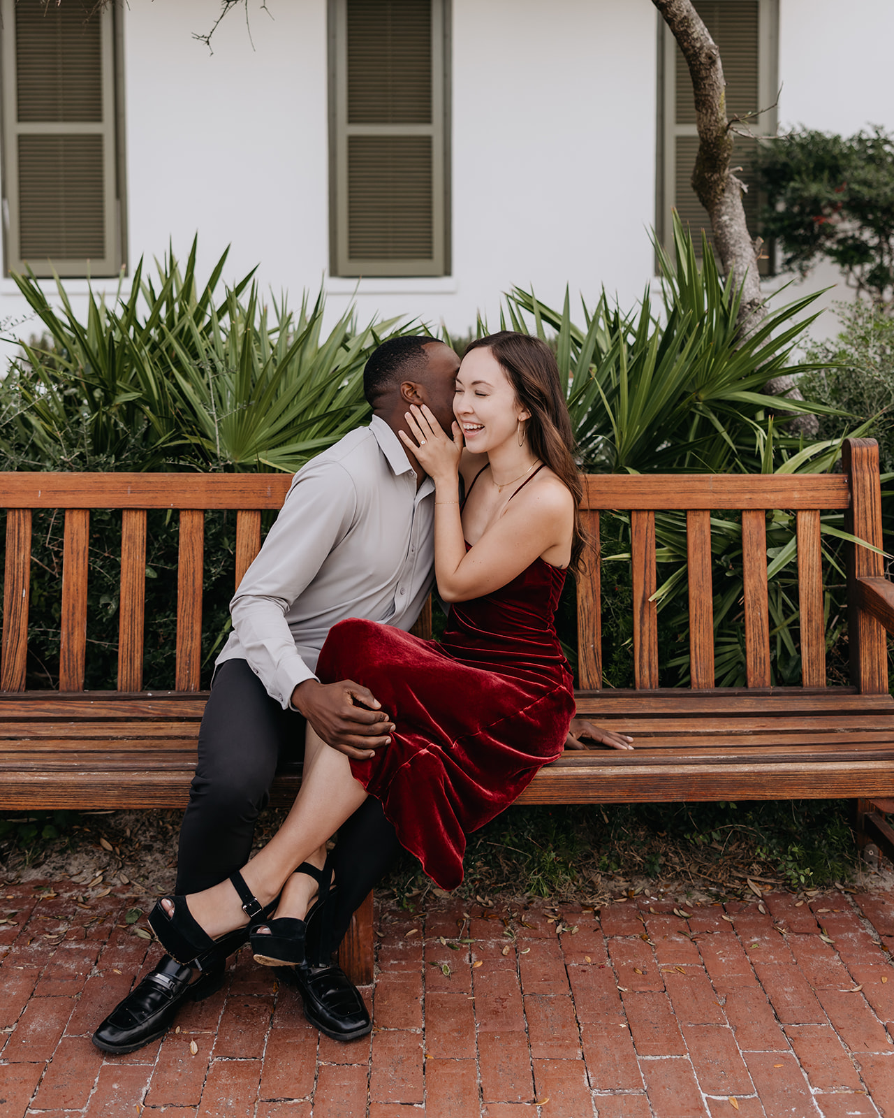 the groom whispers a secret to his bride while enjoying the Rosemary Beach town