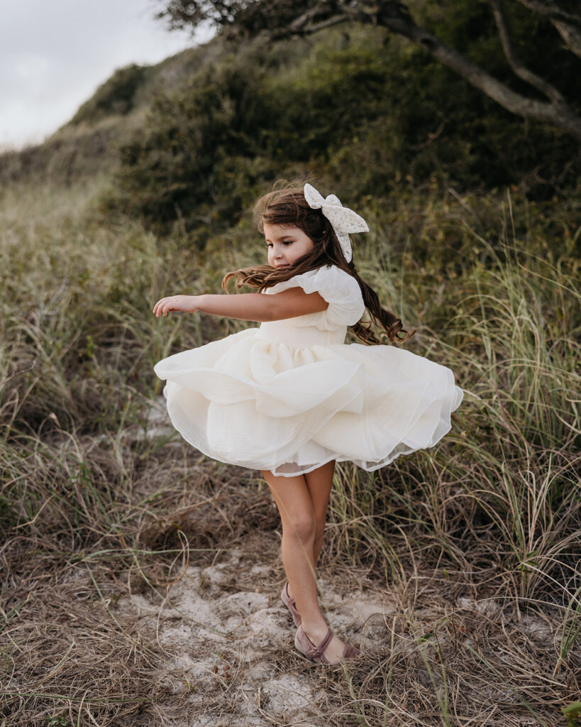 a little girl spins and her dress flows