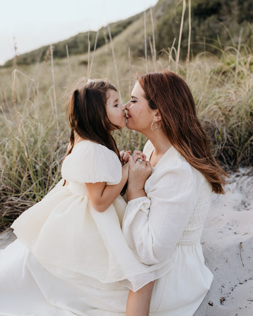 a mother and daughter play in the sand