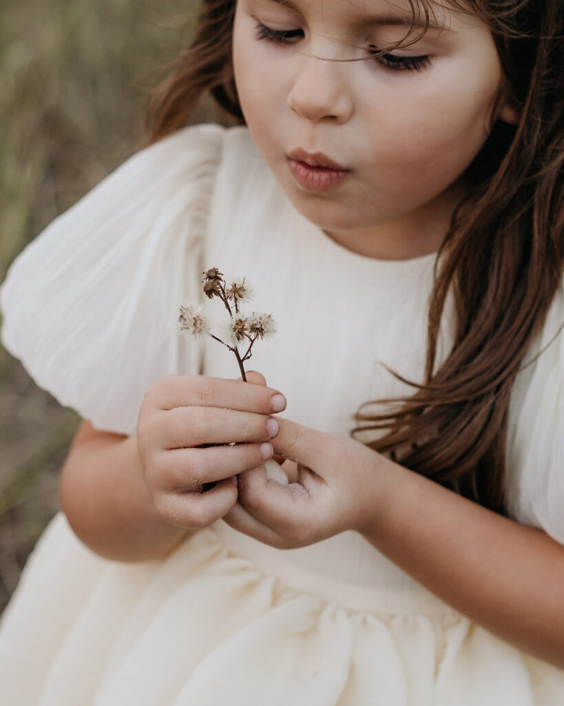 little girl picks a flower