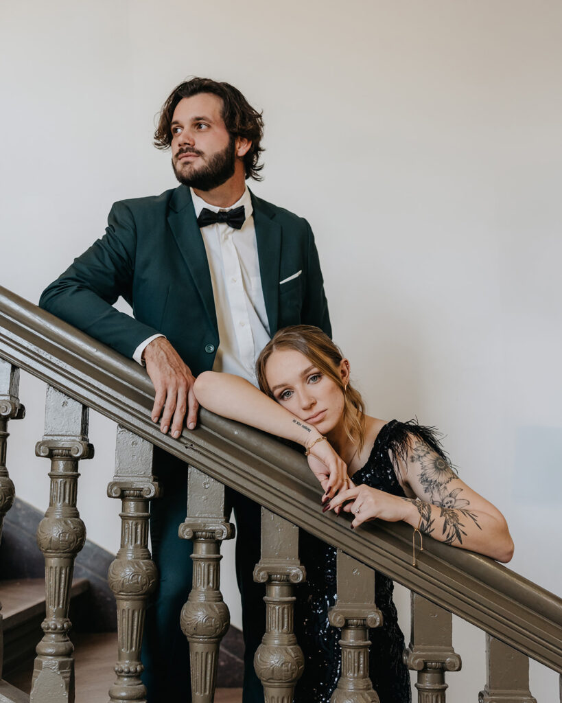 man and woman stand on the staircase and pose