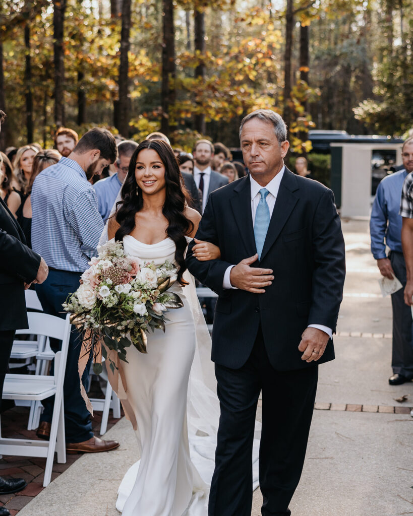 bride walks down the aisle with her father