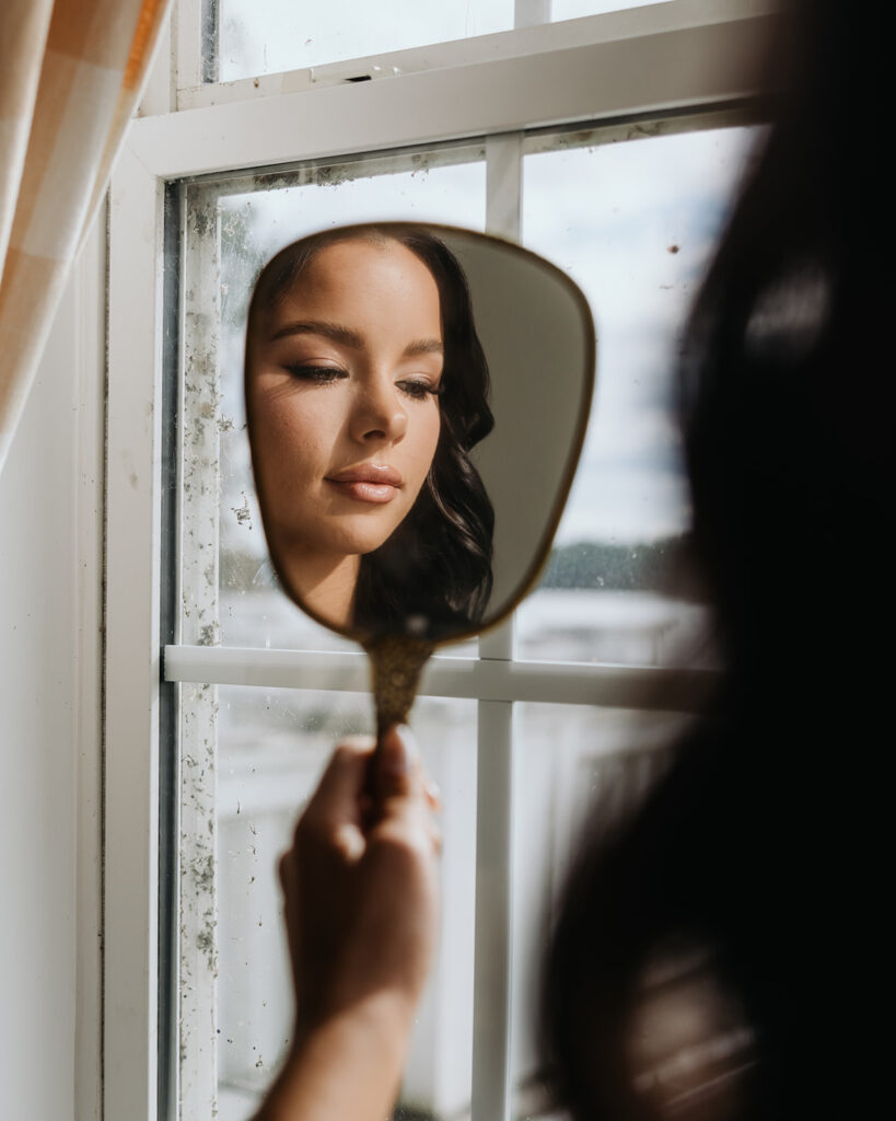 woman looks at herself in a mirror