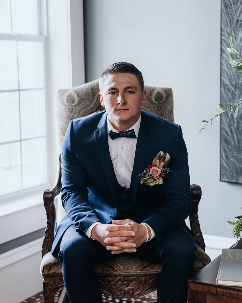 groom sits and looks at the camera