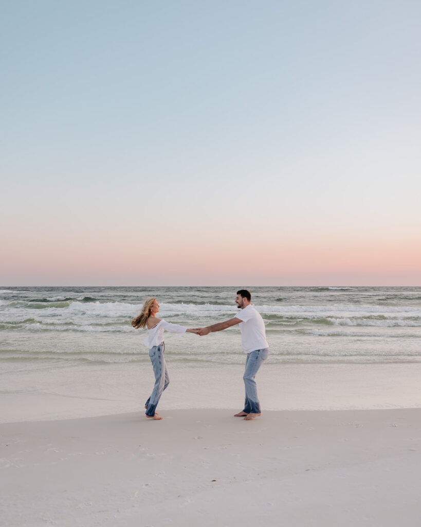 man and woman dance on the beach