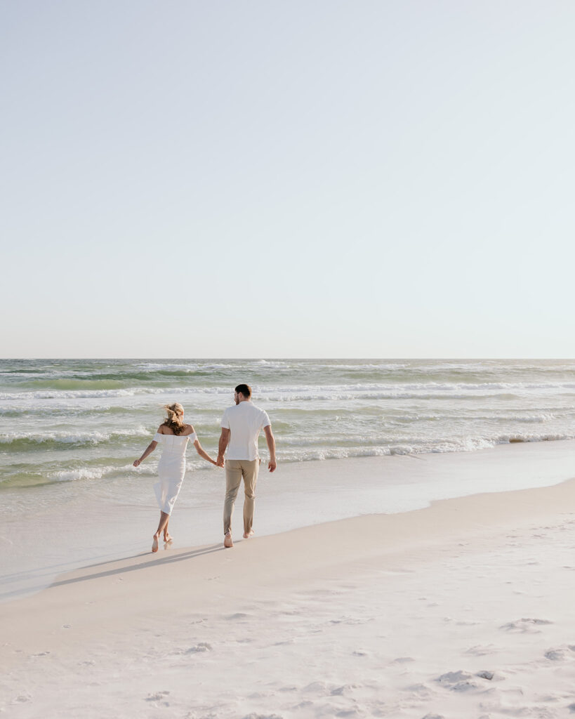 bride and groom walk away on the beach