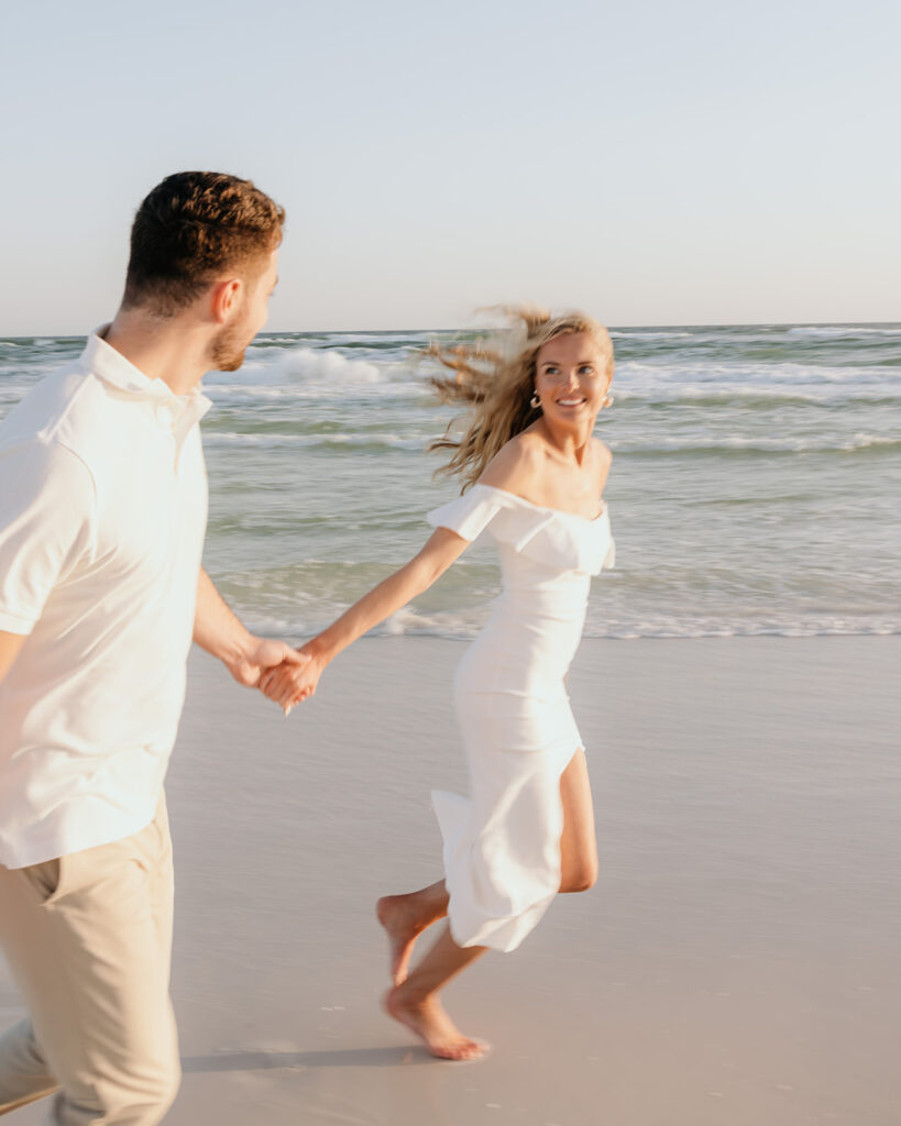 woman and man run on the beach