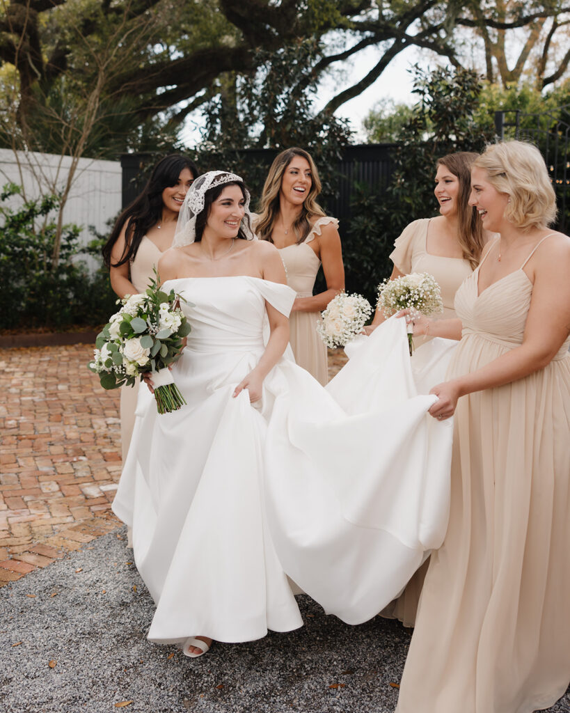 bridesmaids help the bride in her wedding dress