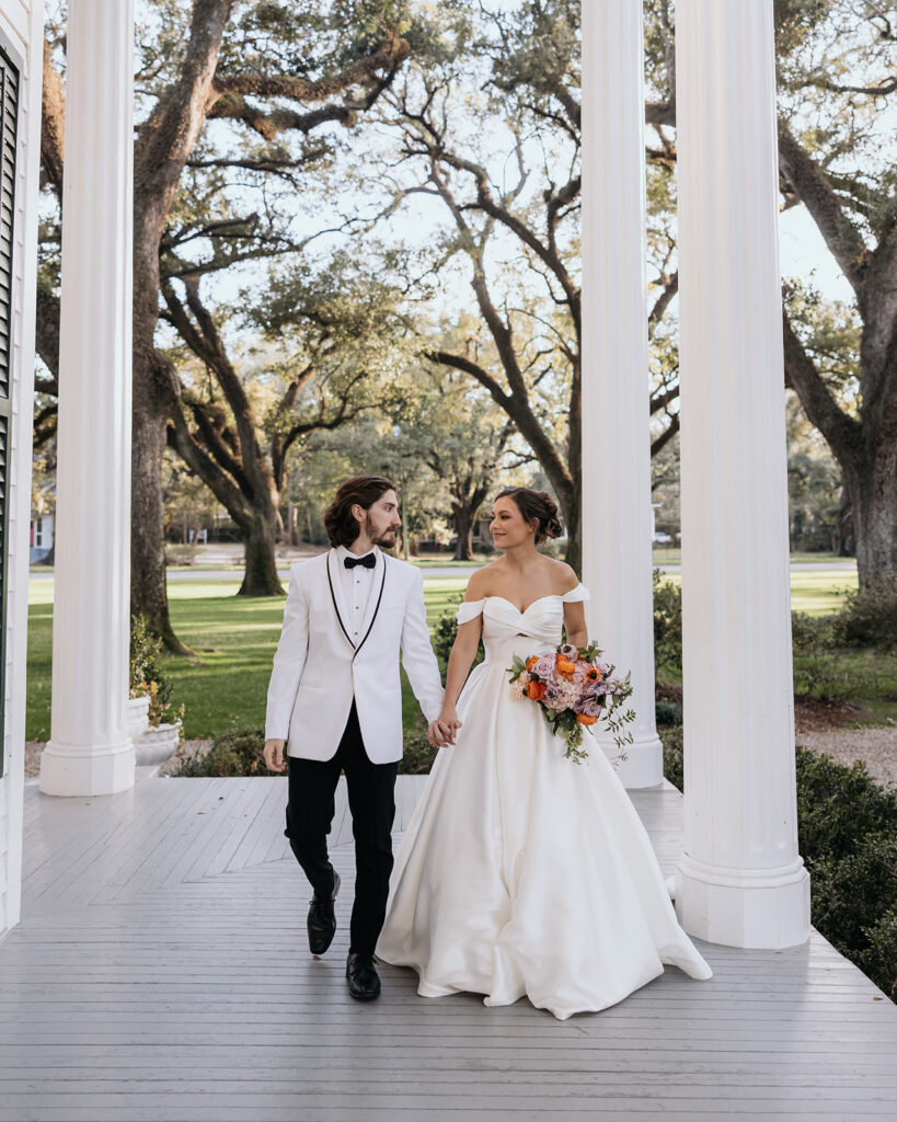bride and groom walk along the Bragg-Mitchell Mansion