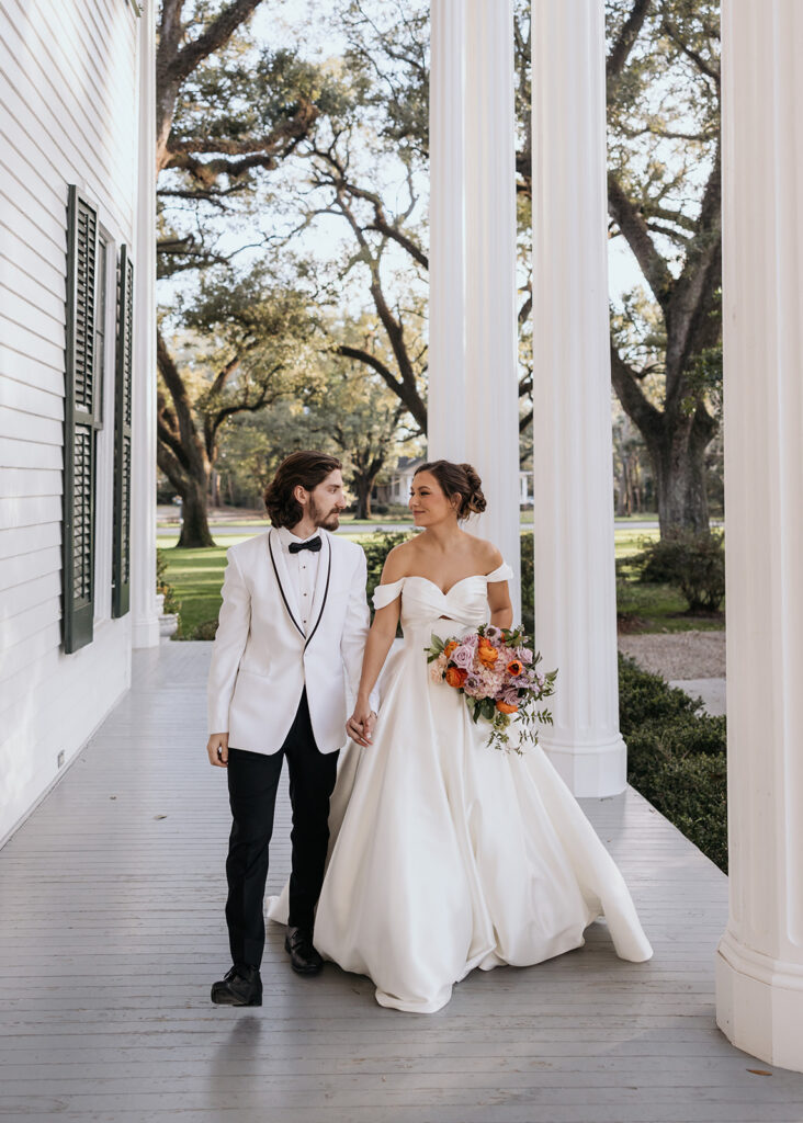 bride and groom walk along the Bragg-Mitchell Mansion