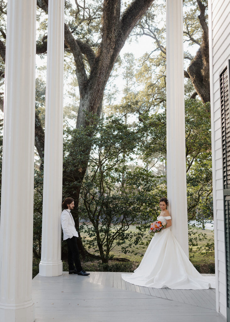 bride and groom lean on building columns
