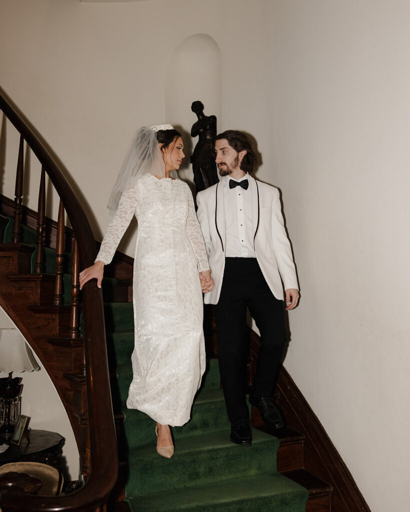 bride and groom walk down the stairs
