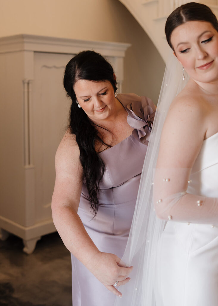 mother zips up the bride's dress