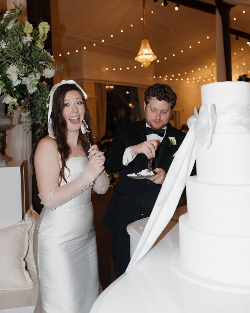 man and woman cut their wedding cake