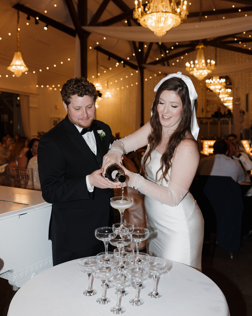 man and woman pour champagne into a tower