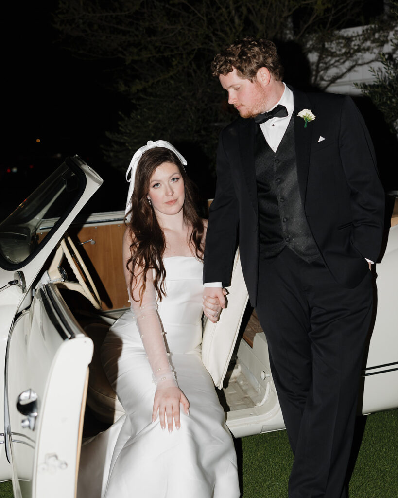 bride and groom pose in vintage car