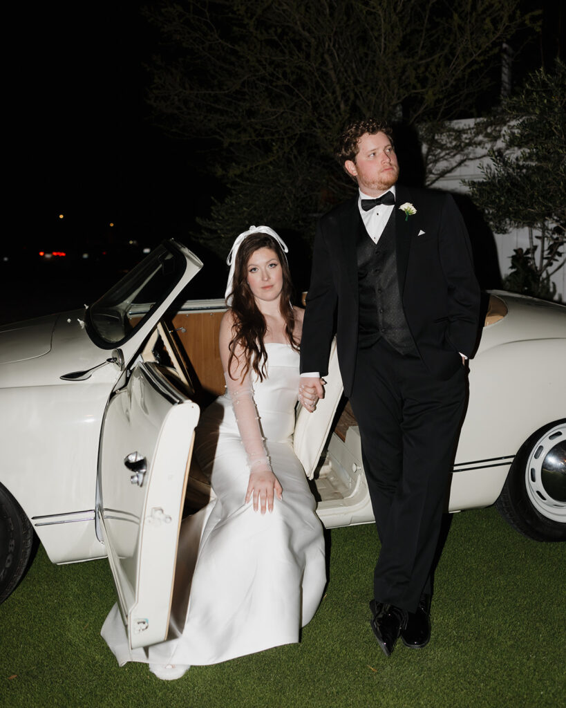 bride and groom pose in vintage car