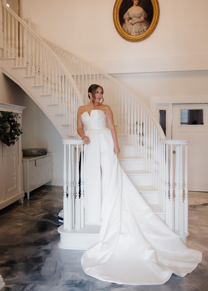 bride poses on Supposey's staircase