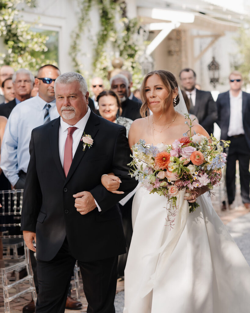 bride and father walk down the ceremony aisle
