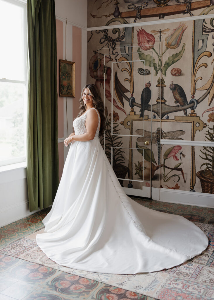 bride poses in her wedding gown in the bridal suite