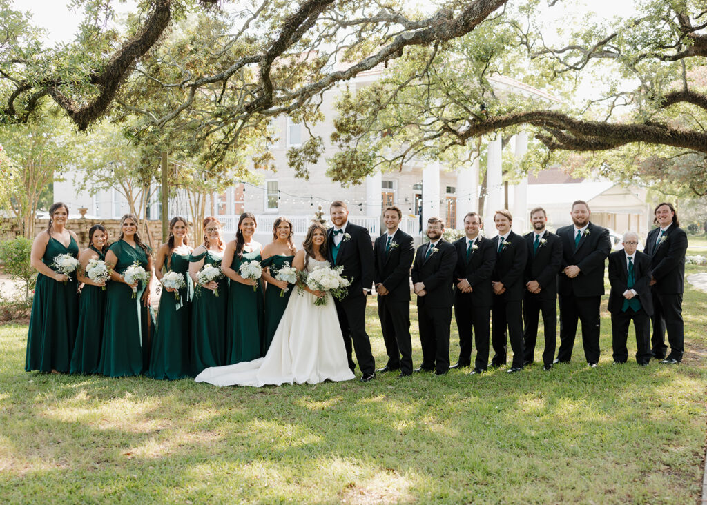 the wedding party stands outside of the Pillars Venue in Mobile, AL