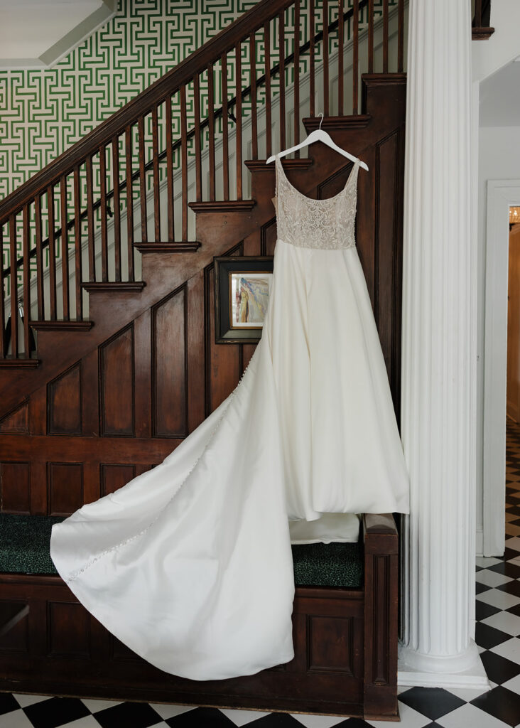 bride's wedding dress hangs on a staircase