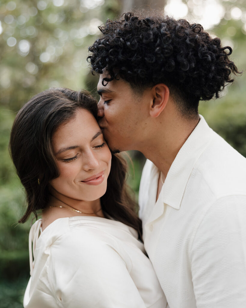 man kisses woman's head