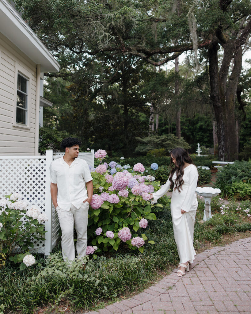 woman touches the flowers as man watches her