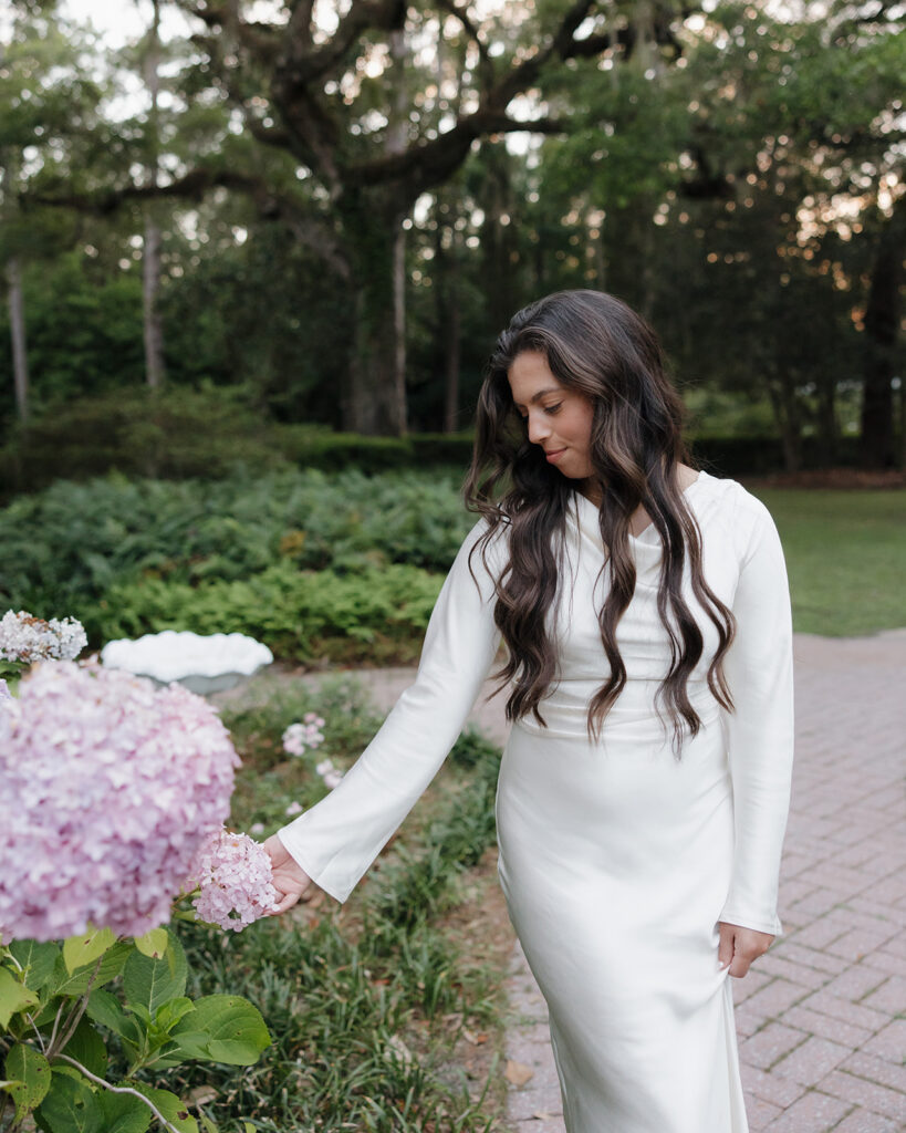 woman touches a flower at Eden Gardens State Park