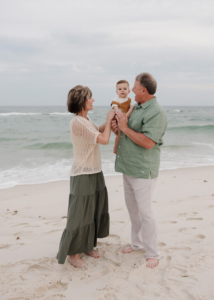 grandparents hold their grandson on Pensacola Beach