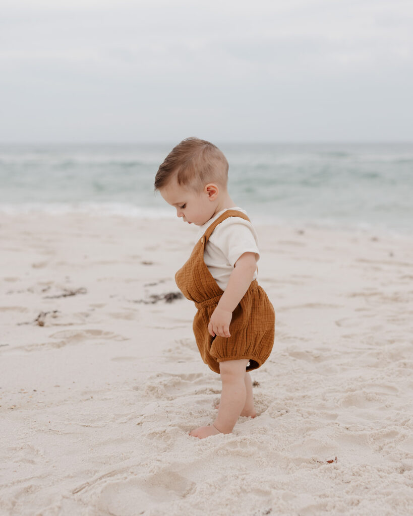 baby boy plays in the sand