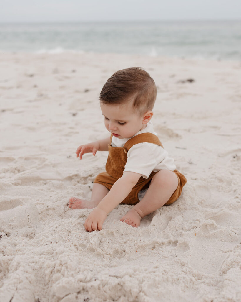 baby boy plays in the sand