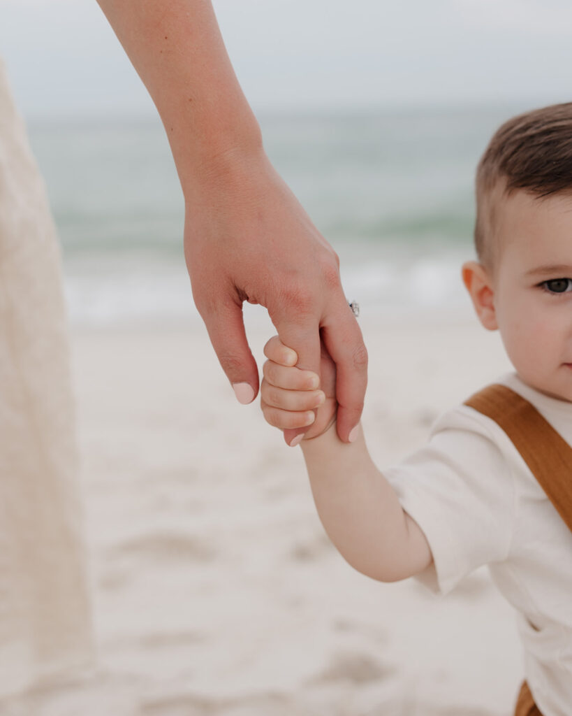 mom holds baby boy's hand