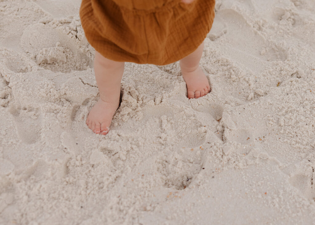 little boy walks in the sand on Pensacola Beach