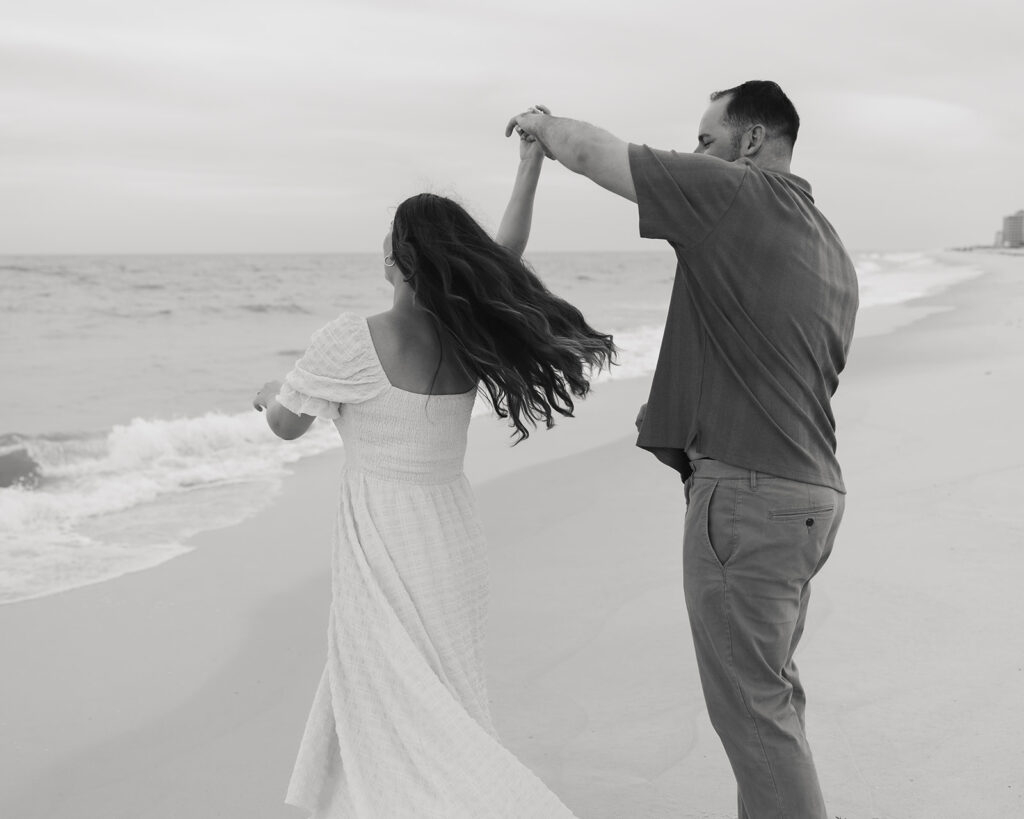 man spins woman around on Pensacola Beach