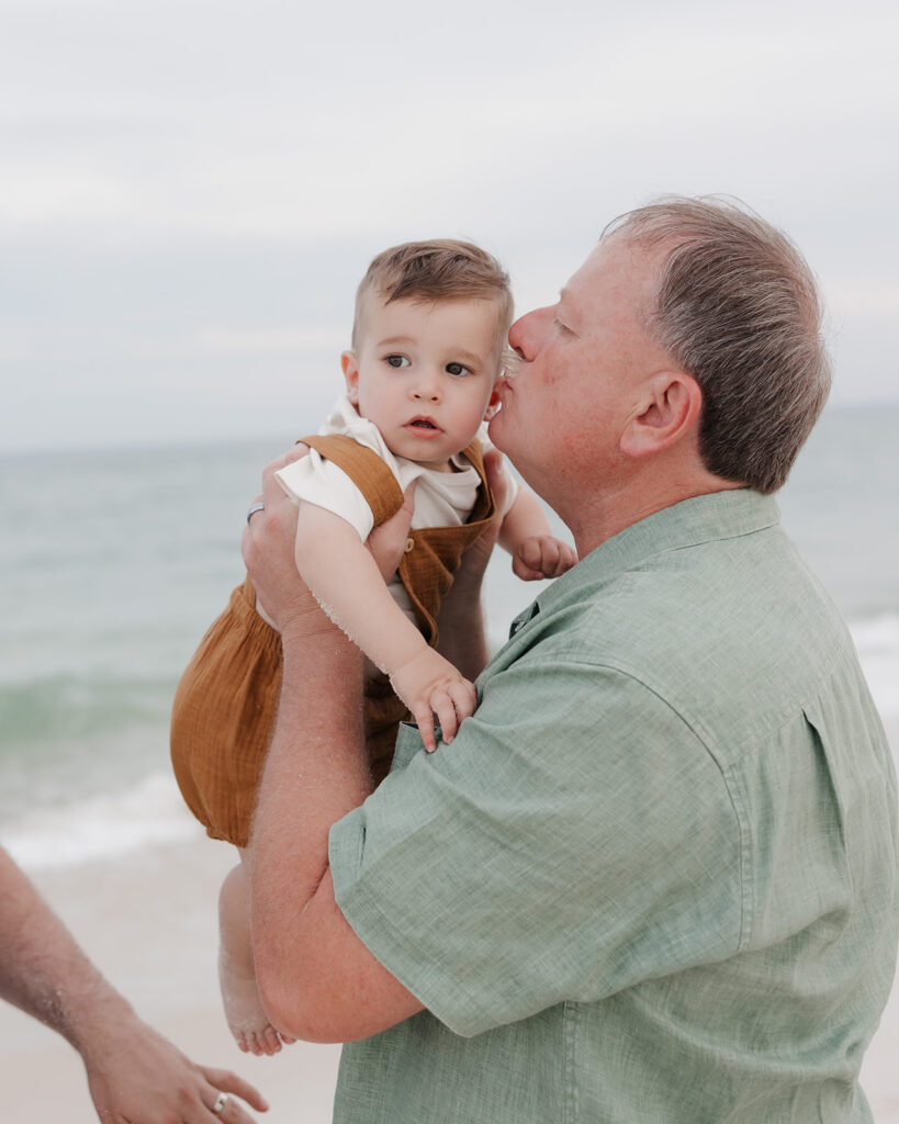 man kisses baby's cheek 