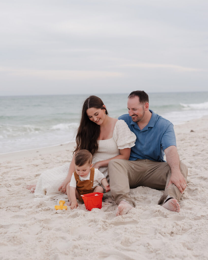 a young family builds a sandcastle on Pensacola Beach